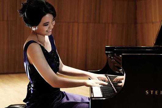 Person in purple dress playing piano